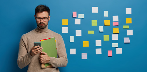 Ein Mann mit vielen strukturierten Postits im Hintergrund